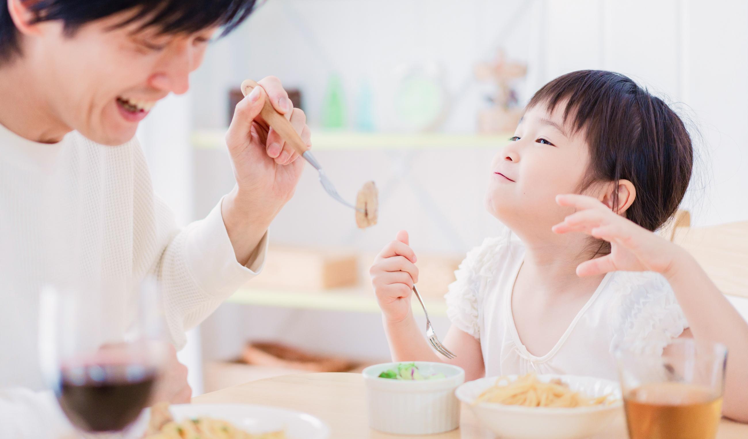 おいしそうに一緒に食事する父と娘